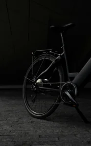 Close-up of a black bicycle’s rear wheel and drivetrain in low light.