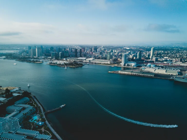 Aerial view of a coastal city skyline with boats in the water.