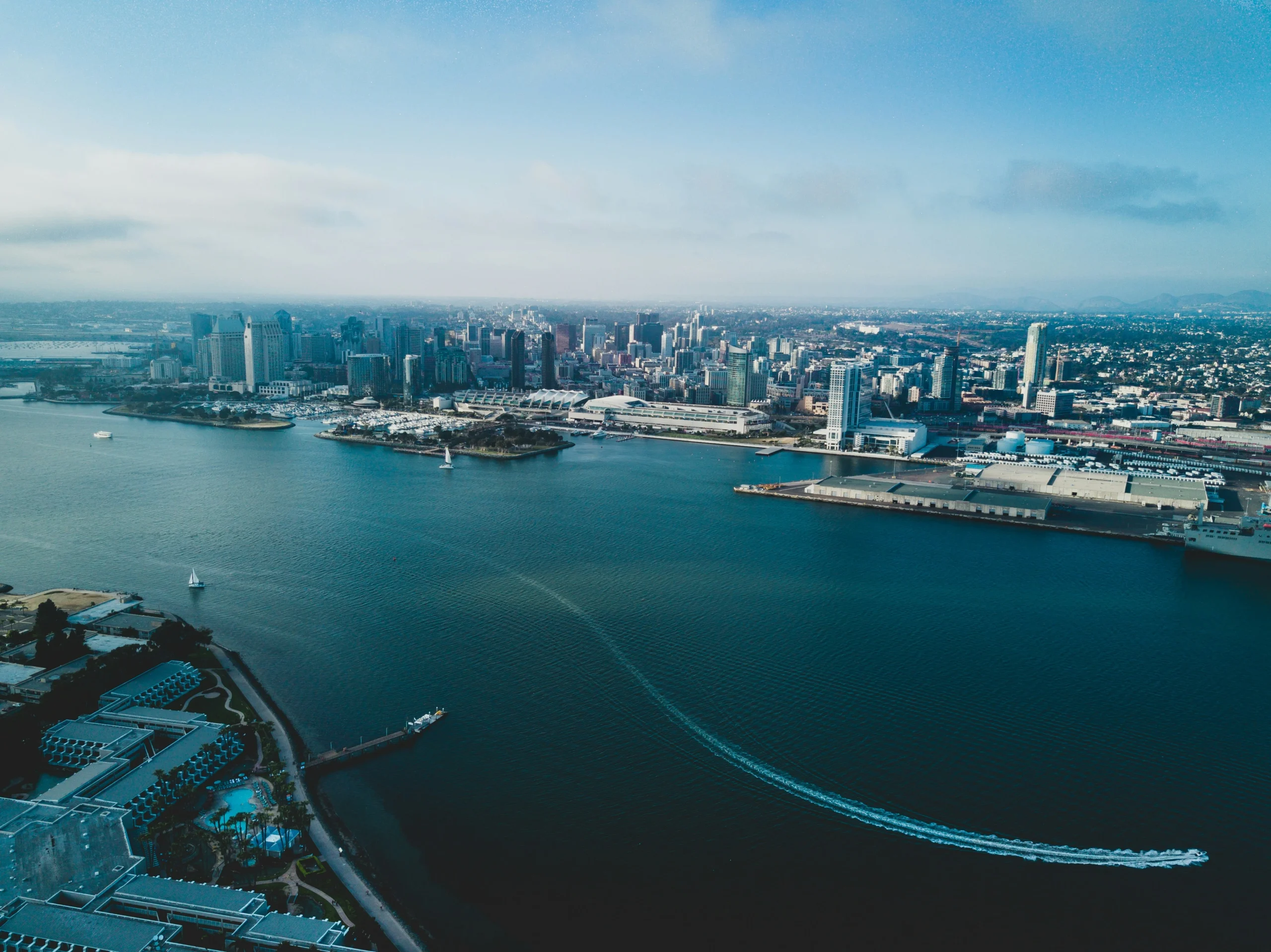 Aerial view of a coastal city skyline with boats in the water.