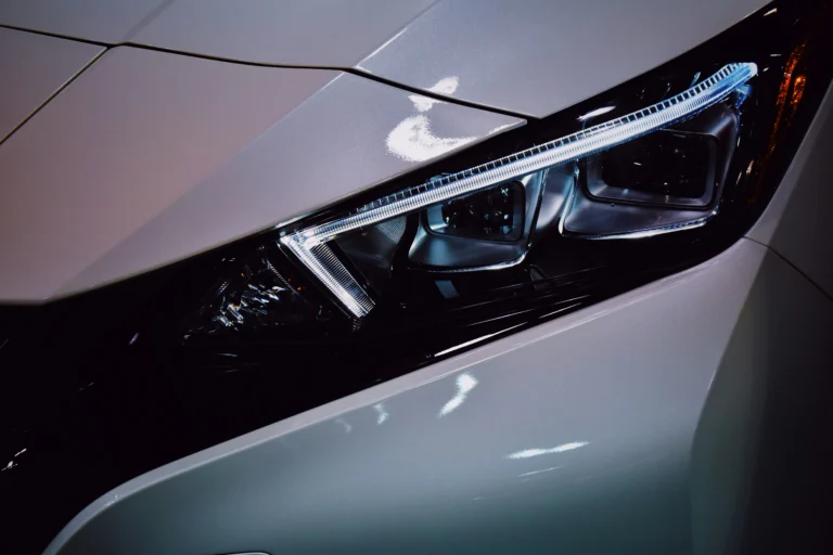 Close-up of a modern car’s headlight and front panel.